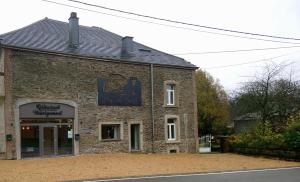 um edifício de tijolos ao lado de uma rua em Jeux de Goûts em Hérissart