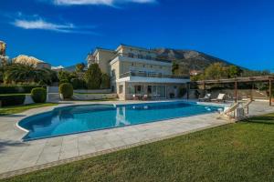 a large house with a swimming pool in the yard at Supreme and Classy Pool Residence in Paianía