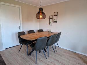 a dining room with a wooden table and black chairs at Vakantiewoning Meidoorn in Meliskerke