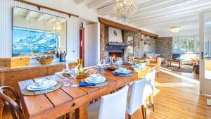 Chalet Monti Della Luna 7, Emma Villas في Bousson: غرفة طعام مع طاولة خشبية كبيرة مع كراسي بيضاء