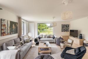 a living room with a couch and a table at LA VILLA DU GOLF - avec piscine couverte chauffée et jacuzzi in Le Tronchet