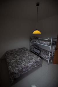 um quarto com uma cama, um candeeiro e uma prateleira em Bilocale Camilla in villa salento em Sant'Isidoro