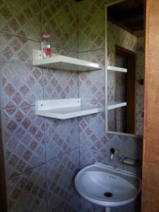 a bathroom with a sink and a toilet and a mirror at Casa de praia na beira do mar in Florianópolis