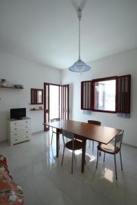 a dining room with a wooden table and chairs at Bilocale Camilla in villa salento in Sant'Isidoro