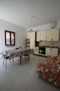 a living room with a table and a kitchen at Bilocale Camilla in villa salento in Sant'Isidoro