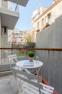 a balcony with a table and chairs on a balcony at Trikoupi 95 by ABR in Athens