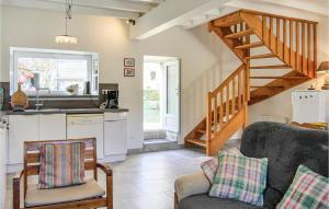 a living room with a kitchen and a staircase at La Petite Mainnerie in Omonville-la-Petite