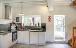a kitchen with white cabinets and a sink at La petite Mainnerie house in Omonville-la-Petite