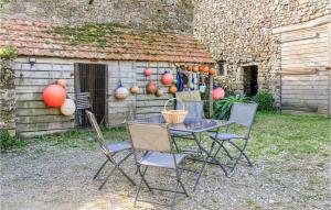 a table and chairs in front of a building at La Petite Mainnerie in Jobourg