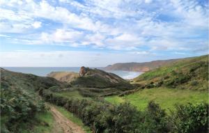 a dirt road leading to the ocean on a hill at La Petite Mainnerie in Jobourg +16 photos