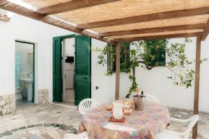 a table and chairs on a patio with a bathroom at Pescoluse Houses in Marina di Pescoluse
