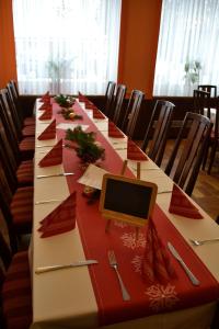 einen langen Tisch mit roten Servietten und einem Computer darauf. in der Unterkunft Gasthof-Pension Leupold in Selbitz