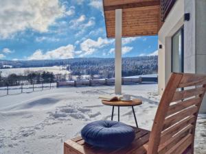 um alpendre com uma mesa e vista para um campo coberto de neve em Lackowa Chill and Rest dom z balią em Uście Gorlickie