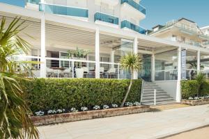 a large white building with stairs and plants at Hotel Atlantico in Lido di Jesolo