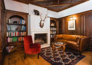 a living room with a leather couch and a fireplace at HENRI Country House Seefeld in Seefeld in Tirol