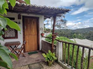 Casa con balcón con puerta de madera en Pousada Cantinho do Dodó en Mulungu