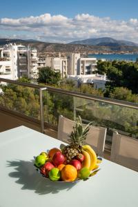 a bowl of fruit on a table on a balcony at Varkiza Luxury Residence in Varkiza