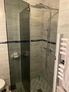 La salle de bains est pourvue d'une douche avec une porte en verre. dans l'établissement Appartement Face à la Mer et au Port Saint Laurent du VAR avec Jardin Privatif, à Saint-Laurent-du-Var