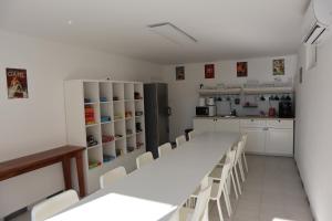 Várvölgy的住宿－Memory Vendégház，厨房配有白色橱柜和长桌及椅子