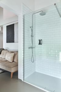 uma casa de banho com um chuveiro e um sofá. em B&B Vossebergen Hombeek 