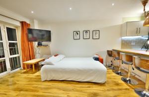 a bedroom with a white bed and a kitchen at The Dubliner Central - O Connell Street Zone in Dublin