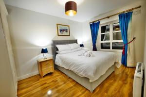 een slaapkamer met een wit bed en blauwe gordijnen bij The Dubliner Central - O Connell Street Zone in Dublin
