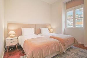 2 bedden in een slaapkamer met een raam bij Pi Houses in Funchal