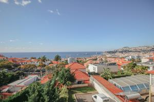 een uitzicht op een stad met oranje daken en de oceaan bij Pi Houses in Funchal