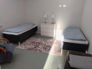 a bedroom with two beds and a rug at Kuhmoisten Kivilinna in Kuhmoinen