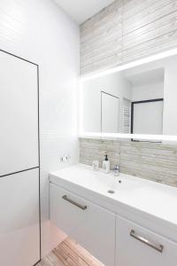 uma casa de banho branca com um lavatório e um espelho em Красива та затишна, дуже тепла квартира з підігрівом підлоги em Dnipro