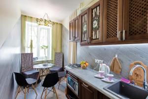uma cozinha com um lavatório e uma mesa com cadeiras em Красива та затишна, дуже тепла квартира з підігрівом підлоги em Dnipro