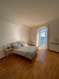 um quarto com uma cama e uma grande janela em CasAmare di Carla em Savona