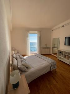 um quarto com uma cama e uma grande janela em CasAmare di Carla em Savona