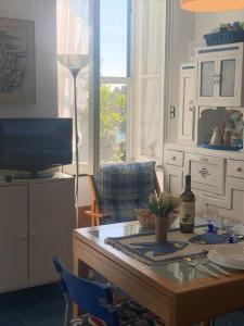 una sala de estar con una mesa con TV y una mesa sidx sidx en Cozy beach house with nice garden, basic feel, en Bonassola