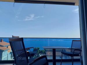 a balcony with a table and chairs and a large window at Apartment in Lokva Rogoznica with sea view, balcony, air conditioning, WiFi 5118-4 in Lokva Rogoznica