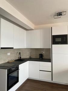 a kitchen with white cabinets and a black counter top at Apartment in Lokva Rogoznica with sea view, balcony, air conditioning, WiFi 5118-4 in Lokva Rogoznica