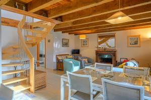 a living room with a staircase and a table and chairs at Kercolo - Maison de campagne à 10min des plages in Surzur