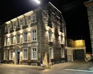 un grande edificio in pietra con luci accese di notte di Residenz Moselliebe a Traben-Trarbach