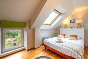 1 dormitorio con cama y ventana grande en Kercolo - Maison de campagne à 10min des plages, en Surzur