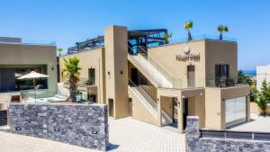 a house with a staircase in front of it at Villaggio Boutique Hotel Hersonissos - Adults Only in Hersonissos