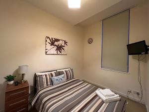 1 dormitorio pequeño con 1 cama y TV en Charming 2-Bedrooms City Centre Apartment en Aberdeen