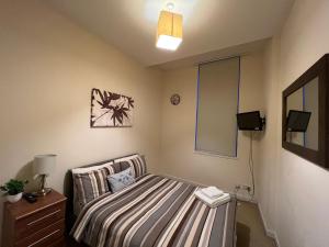 a small bedroom with a bed and a mirror at Charming 2-Bedrooms City Centre Apartment in Aberdeen