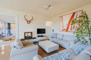 a living room with two couches and a tv at Hof Niglberg Südsteiermark in Sankt Johann im Saggautal