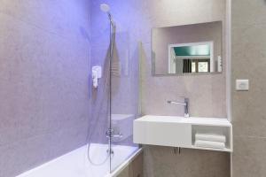 a bathroom with a sink and a glass shower at The Originals Boutique, Grand Hôtel de la Gare, Toulon in Toulon
