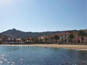 plaża z palmami, budynkami i górami w obiekcie 4PA104 Résidence du Port d'Avall w mieście Collioure