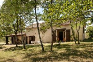 a house with a group of trees in front of it at Gîte La Bergerie - Piscine - Jacuzzi - Paisible - Montcuq en Quercy blanc in Montcuq