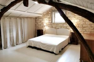 1 dormitorio con cama blanca y ventana en Gîte La Bergerie - Piscine - Jacuzzi - Paisible - Montcuq en Quercy blanc en Montcuq