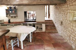 cocina con mesa y pared de ladrillo en Gîte La Bergerie - Piscine - Jacuzzi - Paisible - Montcuq en Quercy blanc en Montcuq