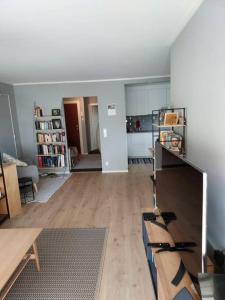 an empty living room with a table and a kitchen at Koselig leilighet i gangavstand til Ullernåsen T-bane stasjon in Oslo