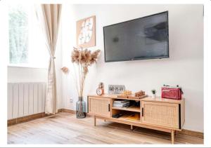 a living room with a television on a wall at Studio calme dans un château au coeur de Caen in Caen